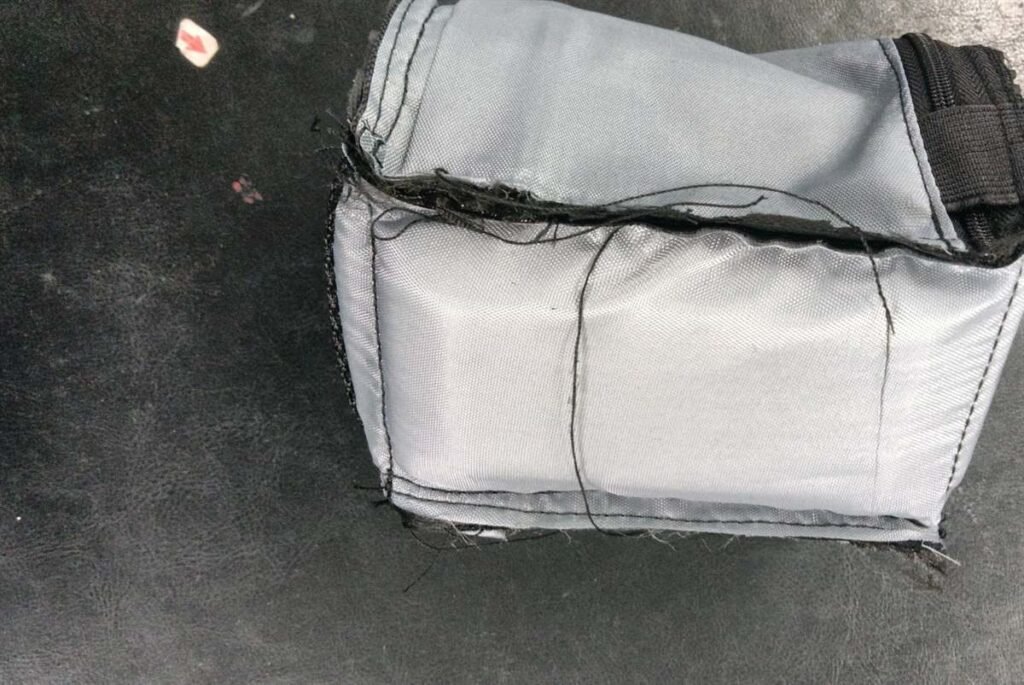 Close-up of a small custom camera case showing formed lining, stitched seams and tight-tolerance construction during production.