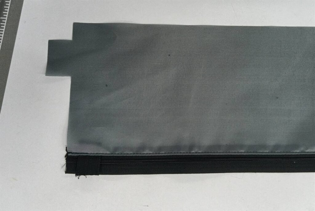 Zipper lining assembly inside a padded camera lens pouch