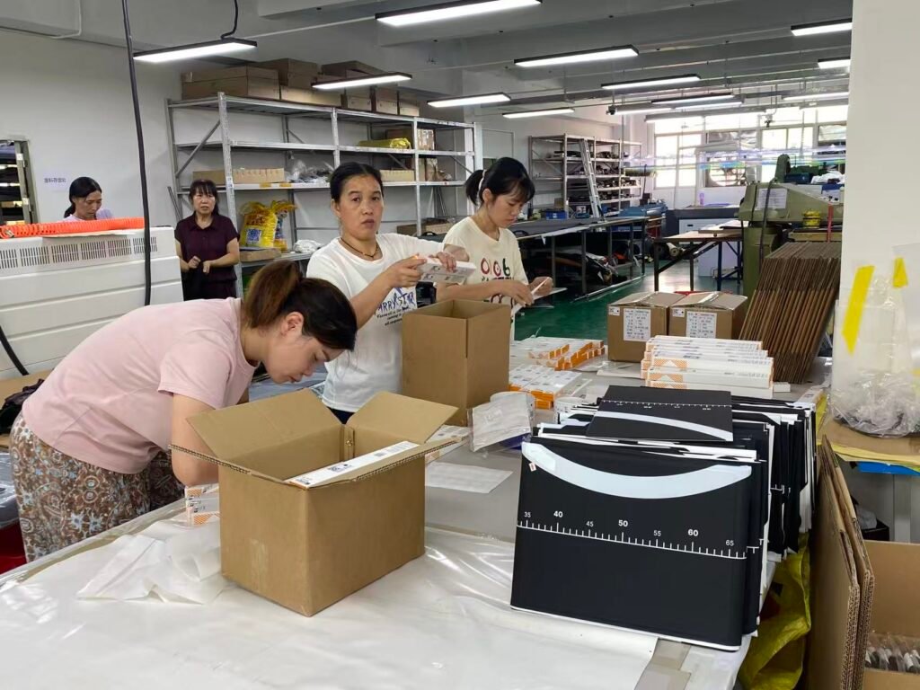 Workers packing finished vlog camera cases for a private-label creator gear order