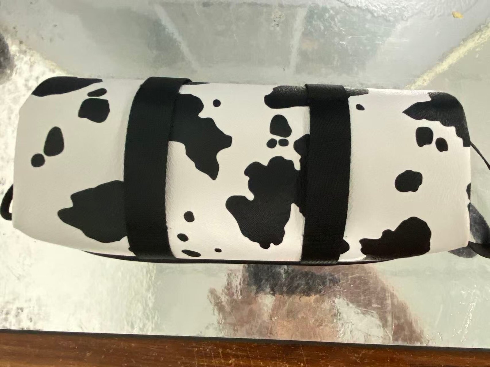 Black-and-white patterned camera case sample with shaped contours on a worktable