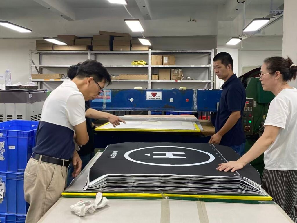 Factory team reviewing a custom drone case panel layout on a production table